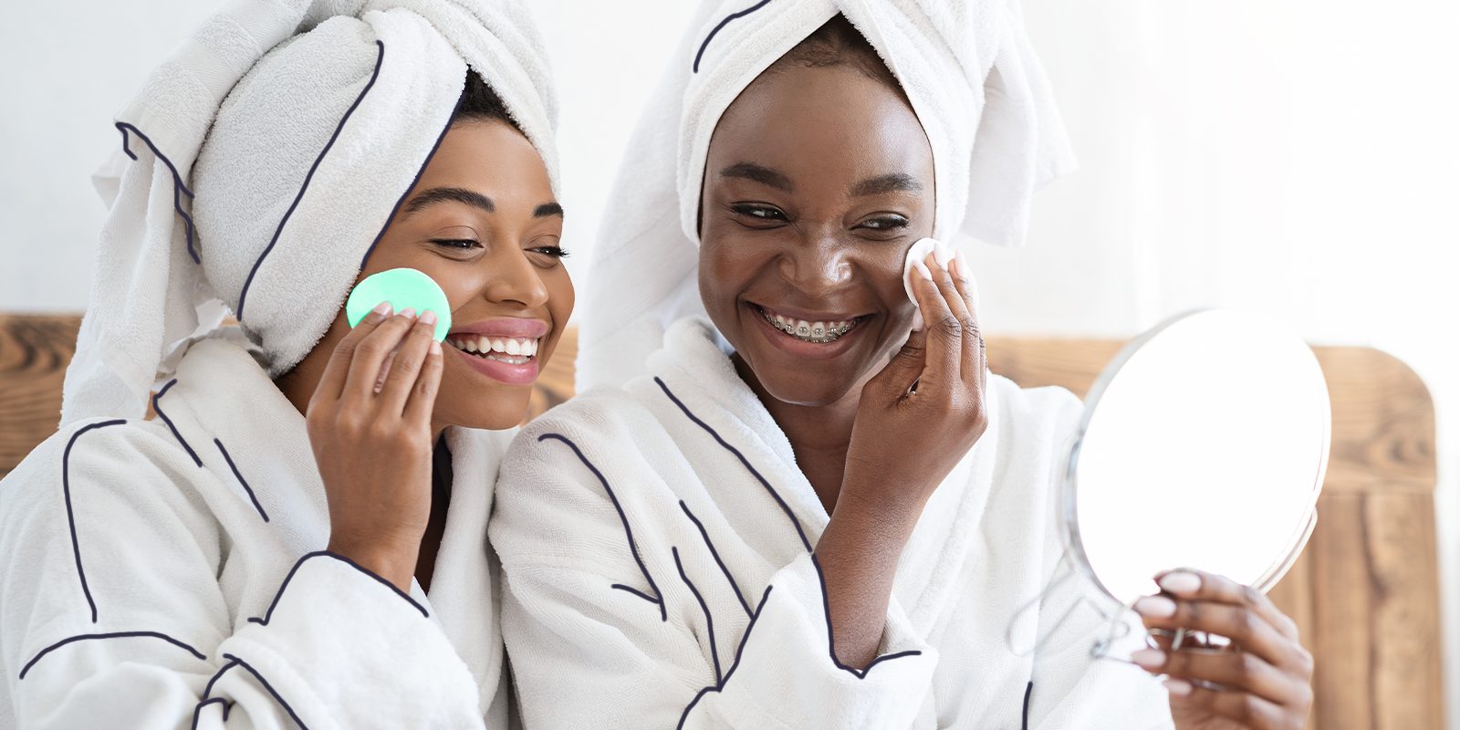 two women using a product and smiling, they are applying makeup
